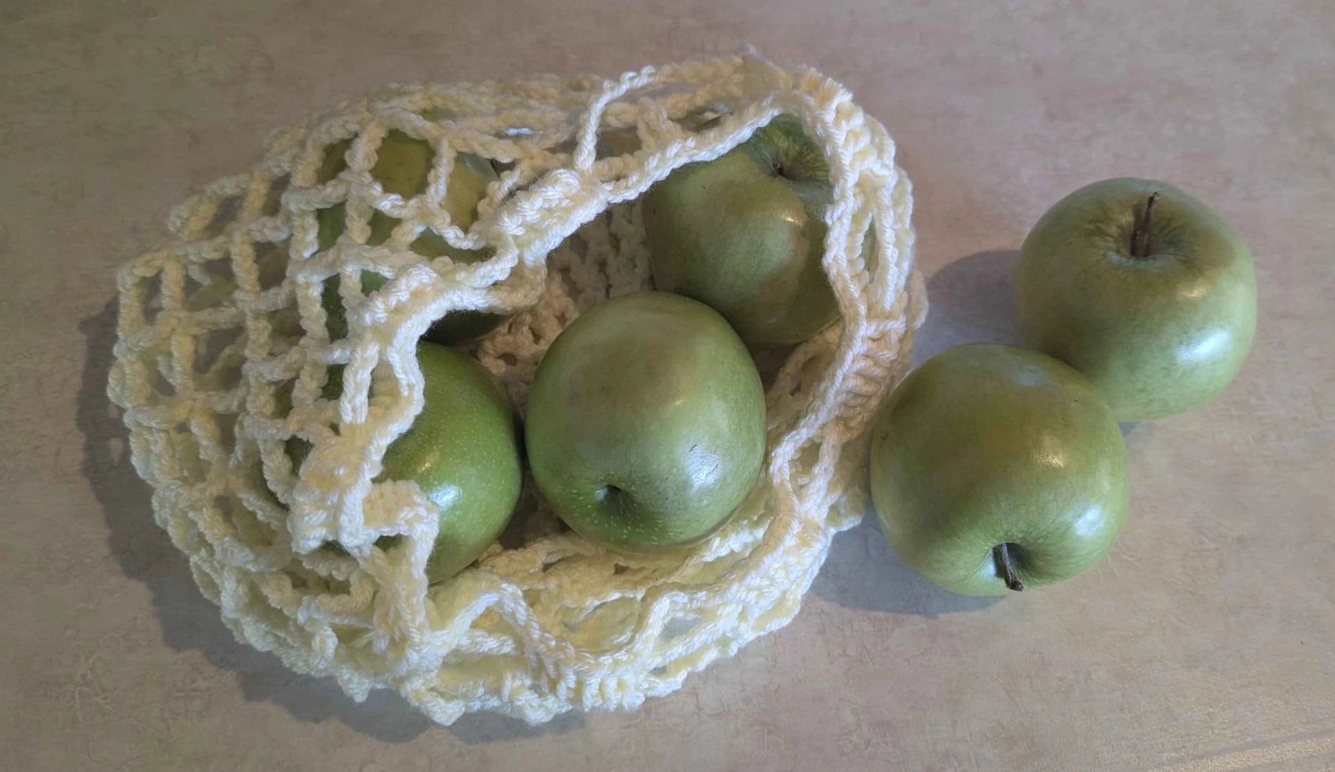 Crocheted bag of green apples